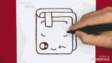a person is drawing a cartoon book with a face on it