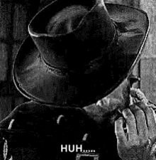 a black and white photo of a man wearing a cowboy hat smoking a pipe .