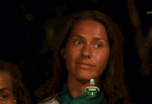 a woman wearing a green shirt that says sadam 5