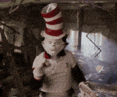 a cat in the hat is wearing a white shirt with the letter o on the sleeve