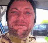 a man with a beard wearing a hat is crying