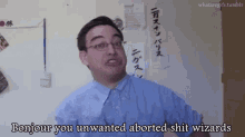 a man wearing glasses is standing in front of a wall and says bonjour you unwanted aborted shit wizards