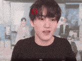 a young man with a red star on his forehead is wearing a black shirt with the name ssomik82 on it
