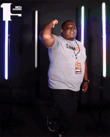 a man wearing a grey shirt that says clown on it stands in front of a bet awards logo