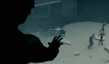 a man 's hand is reaching out towards a group of people in a dark room
