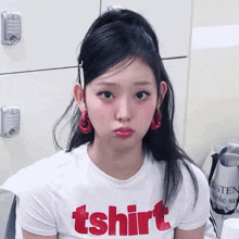 a woman wearing a white t-shirt that says tshirt