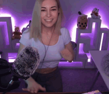 a woman wearing headphones stands in front of a microphone in a room with purple lights