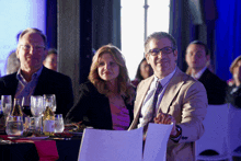 a man and a woman sit at a table with a sign that says a on it