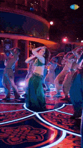 a woman in a green dress is dancing on a dance floor
