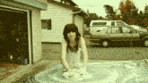 a woman is washing a car with soap and water