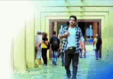 a man in a plaid shirt walks down a hallway