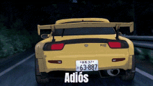a yellow sports car with the license plate 63-887 is driving down a road