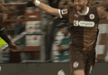 a soccer player wearing a congstar jersey celebrates