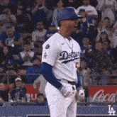 a dodgers baseball player stands in front of the crowd