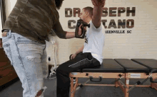 back treatment dr joseph cipriano dc massage gun arm massage chiropractor