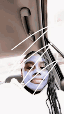 a girl in a car with a purple face mask on