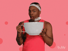 a man in a red tank top is holding a white cup with the word girl written on it