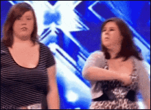 two women are standing in front of a blue background with a 4gifs.com watermark