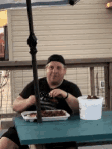 a man is sitting at a table with a tray of food