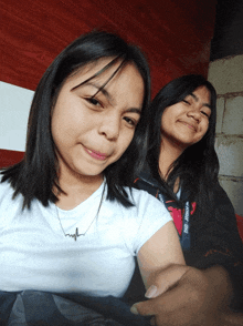 two girls are posing for a picture and one has a lanyard that says php junior on it