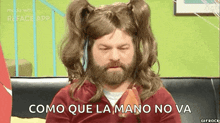 a man with a beard and pigtails is sitting on a couch eating a piece of fruit .
