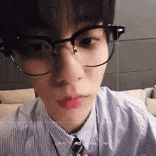 a close up of a person 's face with glasses and a tie