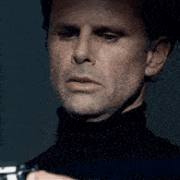 a close up of a man 's face with a turtleneck