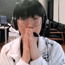 a person wearing headphones and glasses is praying .