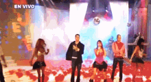 a group of people are dancing on a stage with the words en vivo in the corner
