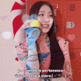 a woman is holding a tennis ball in her hand with the words yo cuando le pertenezco unicamente a xiare below her