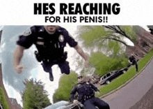 a police officer is riding a motorcycle down a street while another police officer is reaching for his penis .
