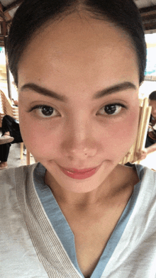 a close up of a woman 's face with a few chairs in the background