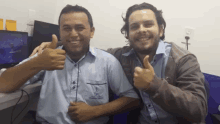 two men are posing for a picture and one has a shirt that says ' fisher ' on the pocket