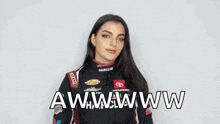 a woman in a racing suit is holding a sticker that says `` menards '' .