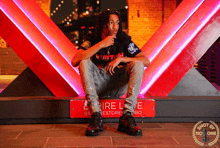a young man sitting on a red sign that says empire lane
