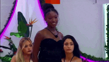 three women are standing next to each other in a room .