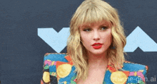taylor swift is standing on a red carpet wearing a colorful jacket .