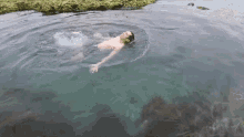 a man is swimming in a body of water with his head above the water