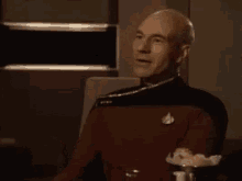 a man in a star trek uniform is clapping his hands .