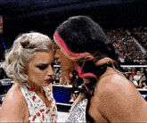 a woman with pink hair is kissing another woman