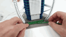 a person is making a tower out of beads