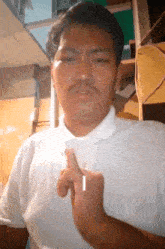 a man in a white shirt is making a gesture with his finger
