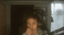 a blurry picture of a person wearing headphones covering their mouth
