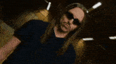 a man with long hair is standing in front of a sign that says " tommy cash "