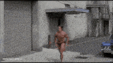 arnold schwarzenegger is running down a street in front of a gallery entrance