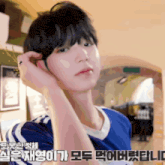a man in a blue shirt is adjusting his hair
