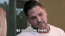 a man with a beard and earrings is talking to a woman and says `` be good in there '' .