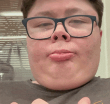 a close up of a person wearing glasses and making a funny face