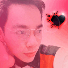 a man wearing glasses looks at the camera with a black heart in the background