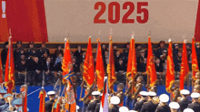 a group of soldiers marching in front of a poster that says 2025